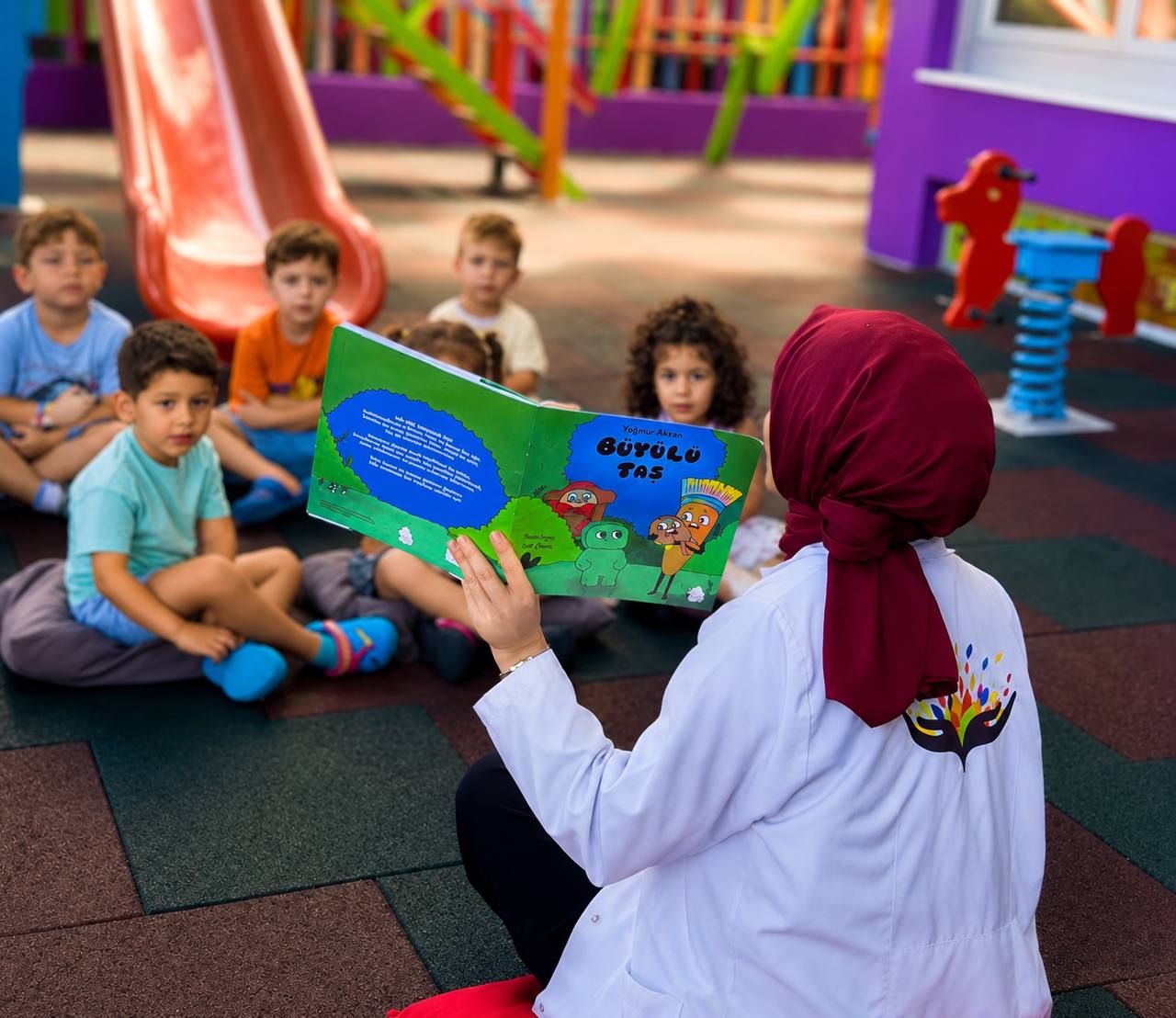 Öğretmen çocuklara kitap okuyor